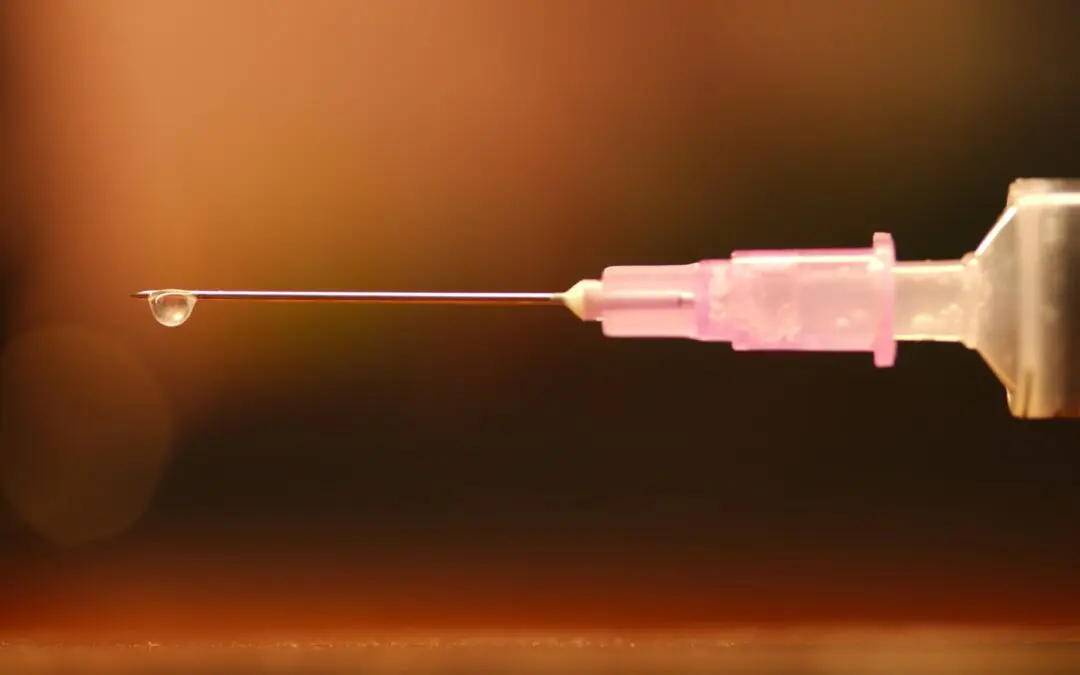 vaccination needle on orange background