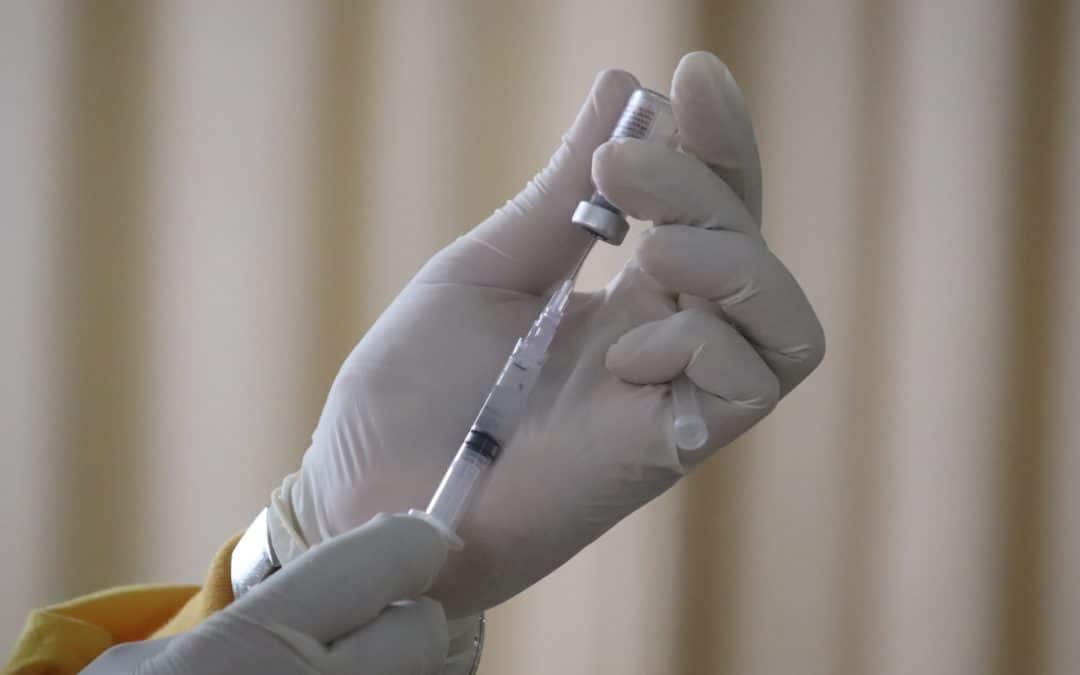 doctor holding vaccine and a needle - annual dog vaccinations